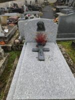 monument gris moucheté avec stèle sur laquelle figure une tête de christ au dessus de l'identification du couple défunt - O.Dufour