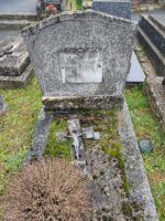 tombe entourage pierre avec croix posée sur le sol et stèle sur laquelle figure une plaque d'identification grise - O.Dufour