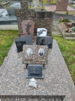 monument tacheté rose et gris avec stèle. une plaque avec photo des deux époux est posée sur la pierre tombale - O.Dufour