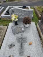monument gris moucheté avec stèle gravée en lettres blanches. sur la pierre tombale est posée une plaque d'identification avec deux photos - O.Dufour