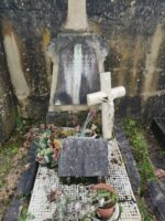 petite tombe entourage pierre avec croix blanche et stèle sur laquelle est fixée une plaque d'identification grise - O.Dufour