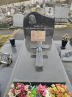 large monument noir avec stèle sur laquelle figure une tête de christ au dessus de l'identification familiale en lettres blanches- sur la pierre tombale centrale est posée une plaque en forme de livre avec l'identification du couple défunt - O.Dufour 
