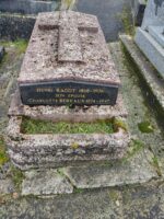 monument en pierre, ancien, surélevé avec croix sculptée sur le dessus et plaque noire d'identification en façade, au dessus de l'espace jardinière -O.Dufour