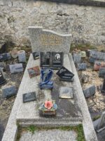 monument gris avec stèle trapeze gravée en lettres dorées. une plaque avec photo d'un homme en uniforme - O.Dufour