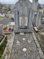 petite tombe entourage pierre et gravillons au centre avec grande stèle sur laquelle est fixée une plaque d'identification blanche - O.Dufour