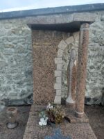grand monument bordeaux moucheté noir avec très grande stèle ou figure l'identification du couple défunt à gauche d'une arche où apparait une forme stylisée peut-être de la vierge et à droite en retour un pilier - o.Dufour