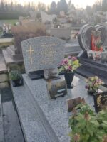 monument gris moucheté avec stèle sur laquelle figure une croix dorée à gauche de l'identification des défunts - O.Dufour