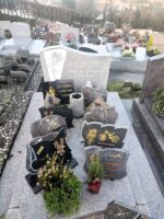 monument gris moucheté avec stèle sur laquelle figure une fleur à gauche de l'identification en lettres blanches - O.Dufour