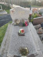 Monument gris moucheté avec stèle gravée en lettres dorées et fleurs à gauche - O.Dufour