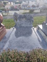 monument gris marbré avec stèle arrondie à droite et en pointe à gauche avec bouquet de fleurs. identification du défunt en lettres dorées - O.Dufour 